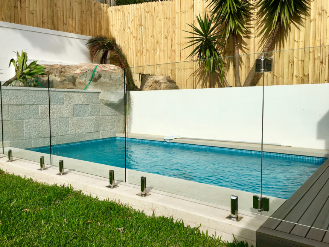 Glass pool fence in core drilled spigots and glass gate